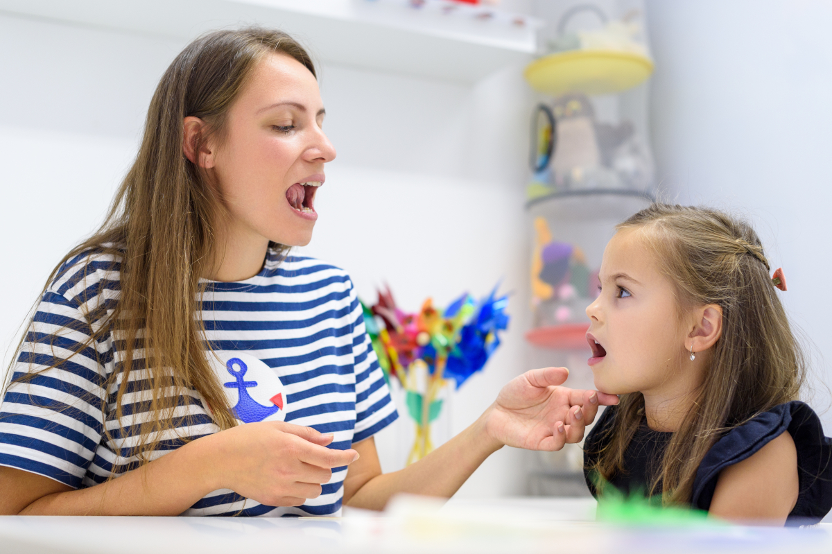 imagen de una mujer junto a una niña trabajando conceptos de logopedia