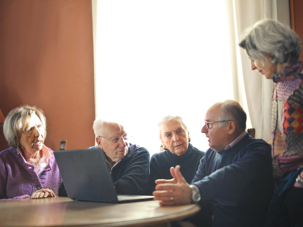 imagen de un grupo de personas senior sentados alrededor de una mesa charlando entre ellos