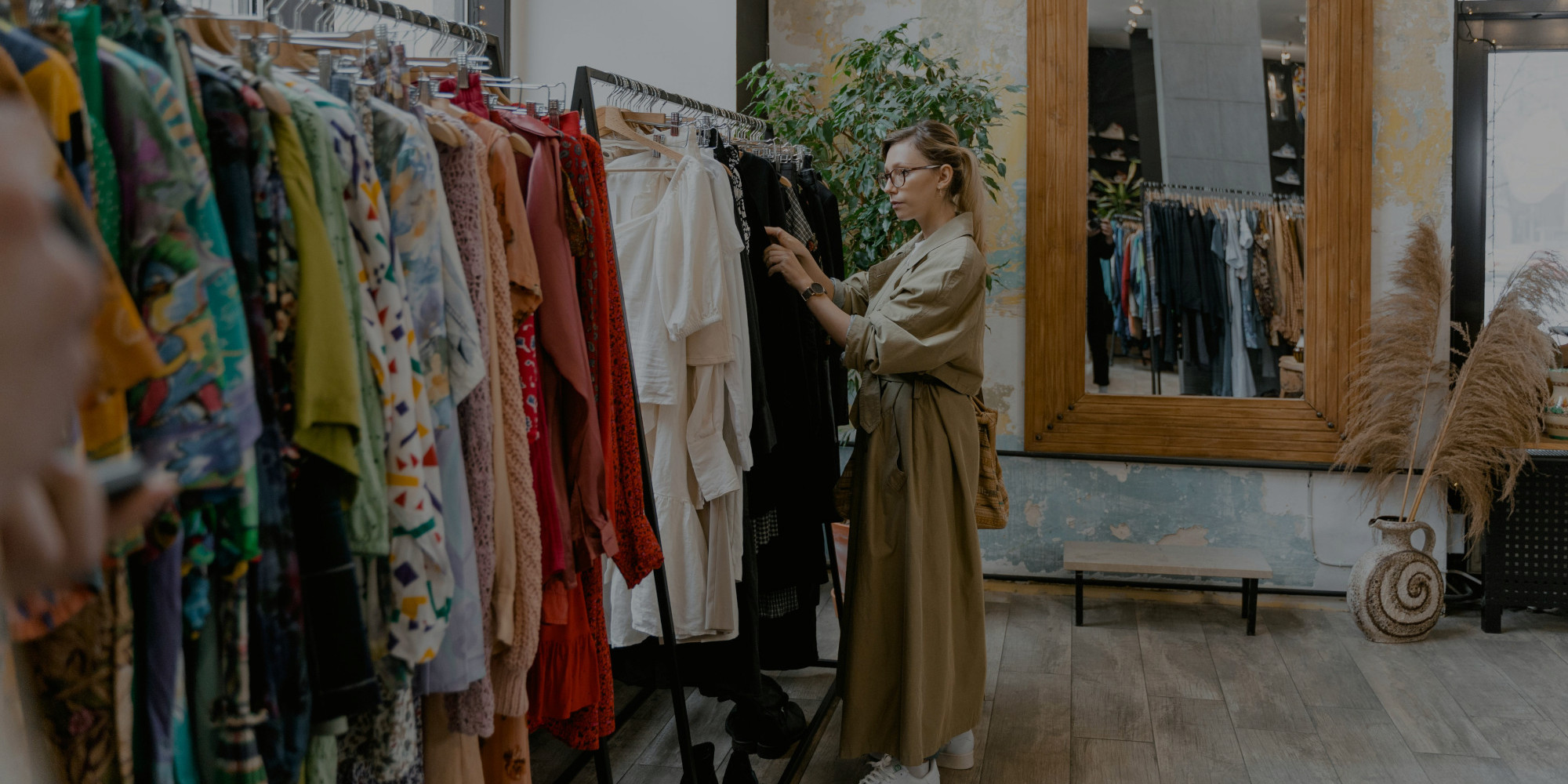 imagen del interior de una tienda de moda donde hay una mujer mirando las prendas